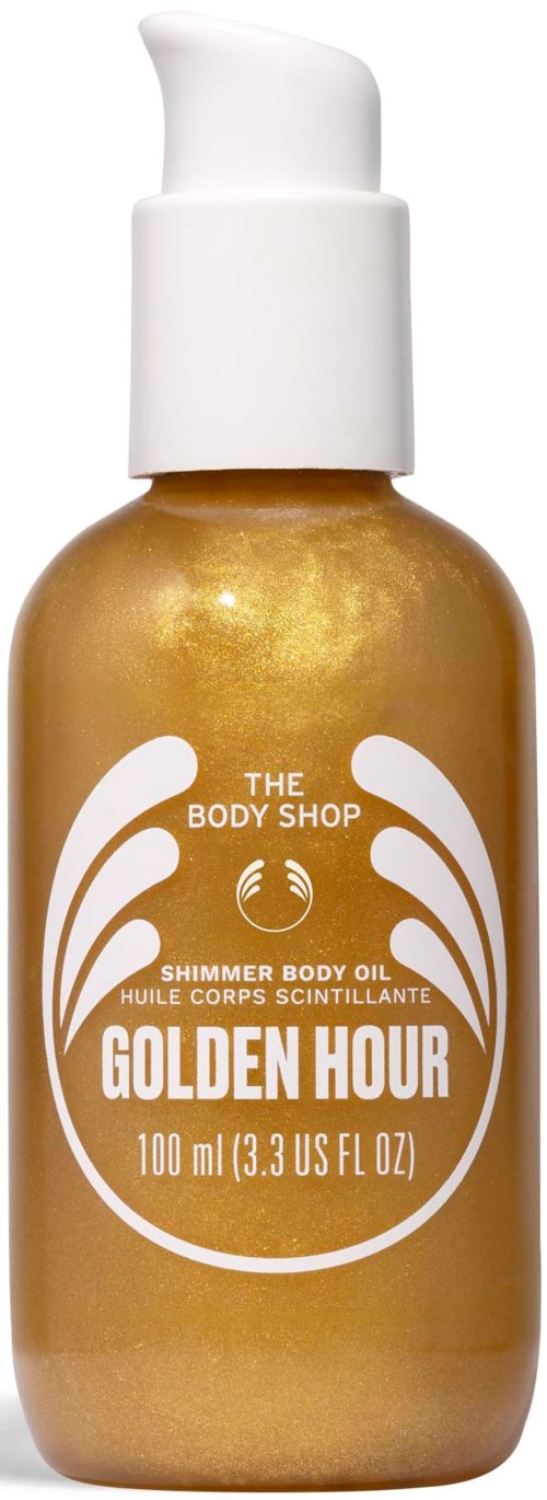 En gyldenflaske med hvid pumpe, mærket Golden Hour shimmer body oil fra The Body Shop.