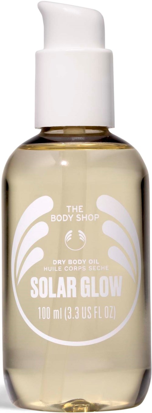 En klar flaske med hvid etikett og pumpe, indeholder tør kropsolie kaldet Solar Glow fra The Body Shop.