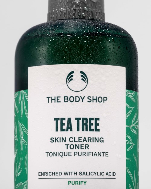 The Body Shop Tea Tree hudrensende tonerflaske med svart hette, hvit etikett og grønt bladmønster.