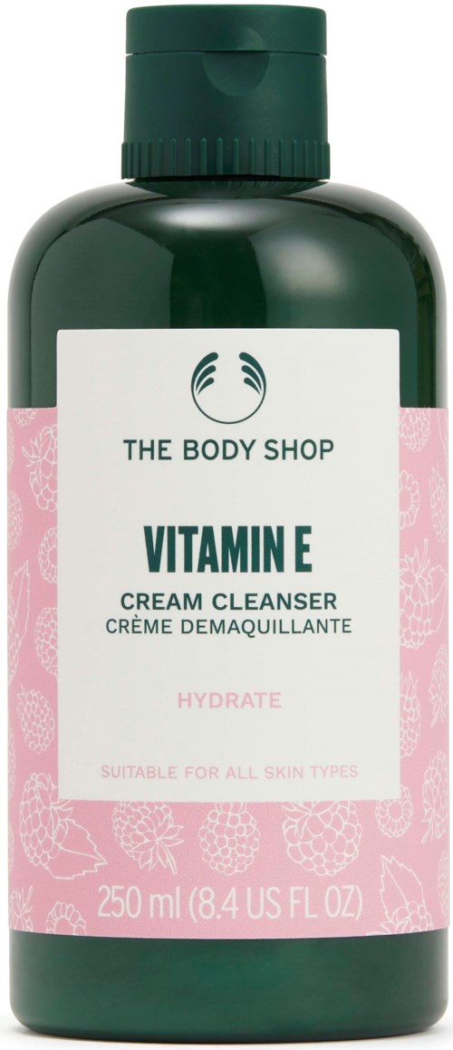 A green bottle of The Body Shop Vitamin E cream cleanser, shaped like a typical bottle with a pink and white label.