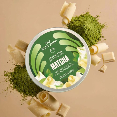 Matcha and white chocolate body butter from The Body Shop, with green matcha powder and white chocolate pieces around.
