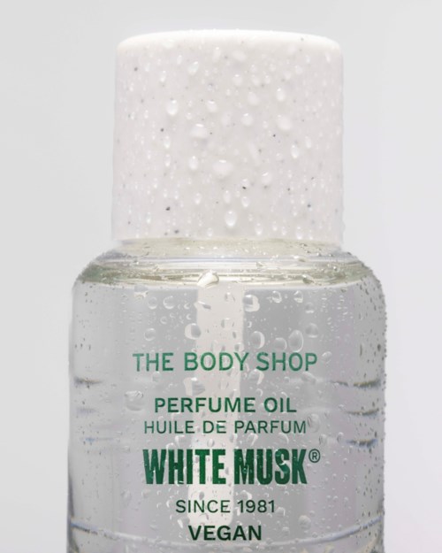 Pullo The Body Shopin hajuöljystä, nimeltä White Musk, vegaani, valkoinen korkki ja kirkas neste sisällä.