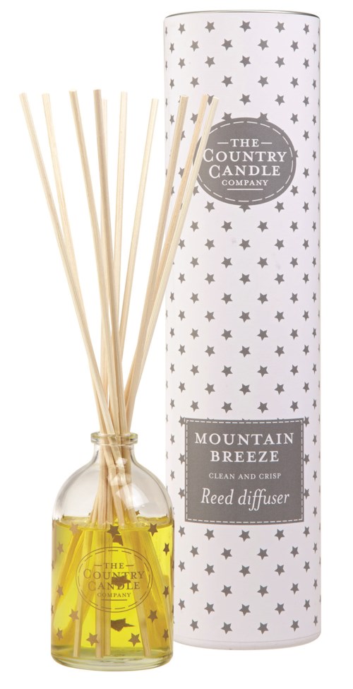 En doftpinnar med gul olja och ljusa pinnar, med stjärnmönstrad förpackning märkt "Mountain Breeze".