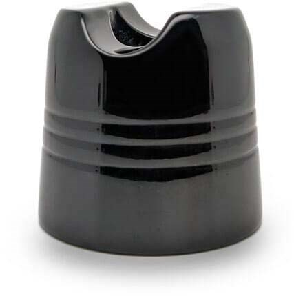 A black round object with three horizontal ridges and a small, curved opening at the top.