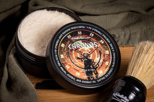 En sort beholder med hvid hårpomade, etiketten har en skalle og ilden, sammen med en barberskum.