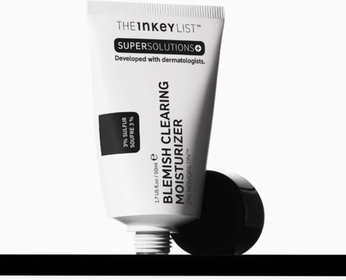 Hvit tube med svart kork, tekst viser at det er en fuktighetskrem og klar hudprodukt, med ingredienser som svovel og kull.