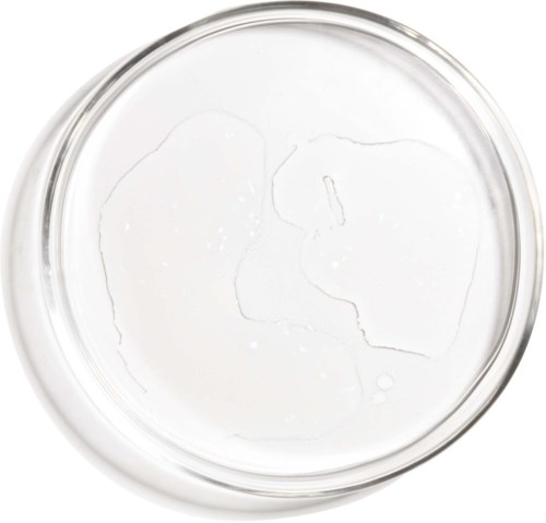 Tydligt vätska i en rund glasbehållare, med några sprickor eller bubblor på ytan.