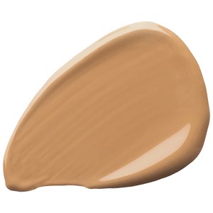 En droppformad klick av beige färgad flytande eller krämig på en vit bakgrund.