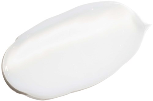 En hvid creme eller lotion er spredt på en hvid overflade, brugt til hudpleje eller skønhed.