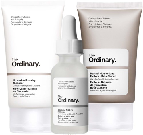 Three skincare products with simple white packaging, labeled for cleansing and moisturizing, from The Ordinary.