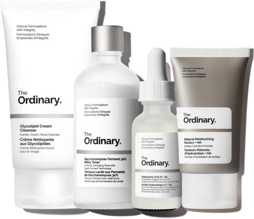 Eine Reihe von Hautpflegeprodukten, darunter Cremes, Seren und eine Tube, mit einfacher weißer und grauer Verpackung von The Ordinary.