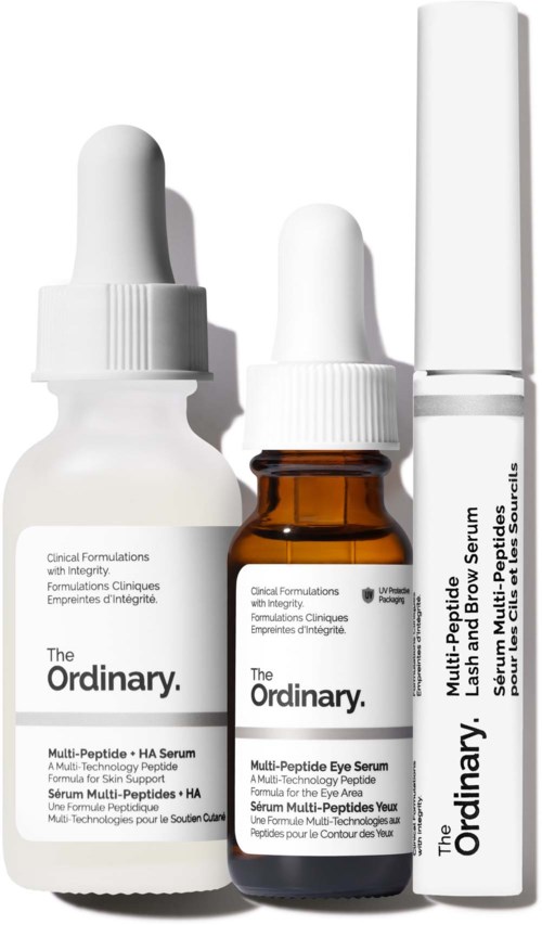 Tre hudpleieprodukter, inkludert serum og en stift, fra The Ordinary, med hvite og ravfargede flasker.