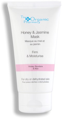 En vit tub med ansiktsmask med rosa och blå etiketter från The Organic Pharmacy, för torr hud med honung, jasmin, squalane och aloe.