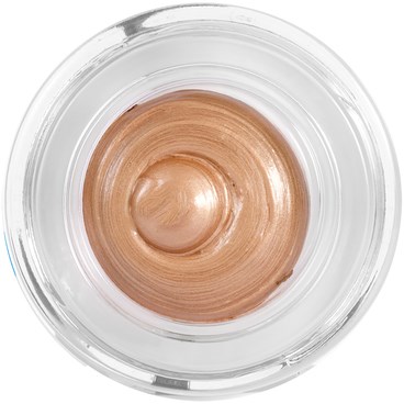 En liten behållare med glänsande beige kräm, sett uppifrån.