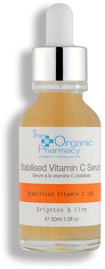 En liten glasflaska med dropplikon, märkt för C-vitamin serum för att ljusa och strama huden.