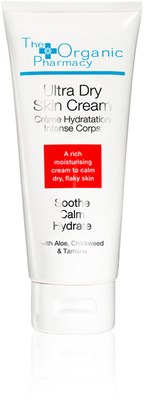 En vit tub med hudkräm märkt 'Ultra Dry Skin Cream' med blå och röd text, avsedd för torr, fjällande hud.