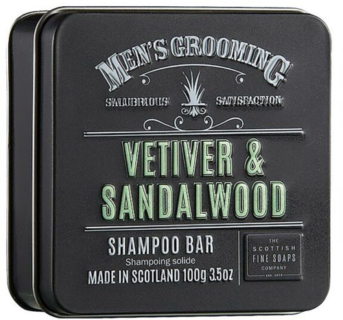En svart pleieeske med grønn og hvit tekst for herreshampo, duft av vetiver og sandeltre, laget i Skottland.