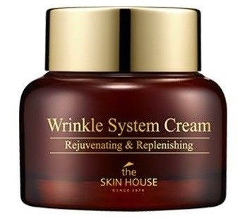 En burk märkt Wrinkle System Cream av The Skin House, guldlock, mörkbrun behållare, för hudvård.