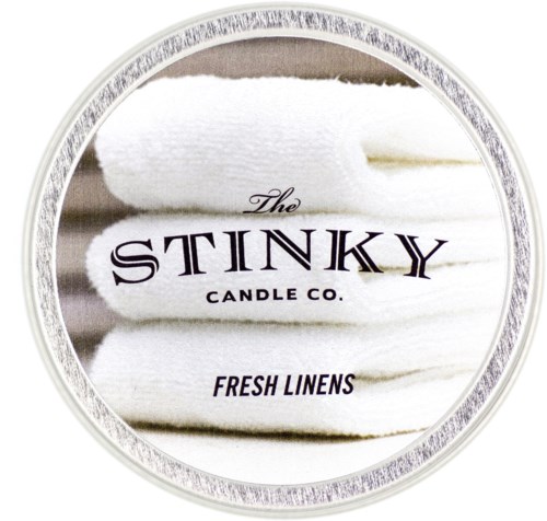 En rund etikett med vita vikta handdukar och svart text som säger "The Stinky Candle Co. Fresh Linens."