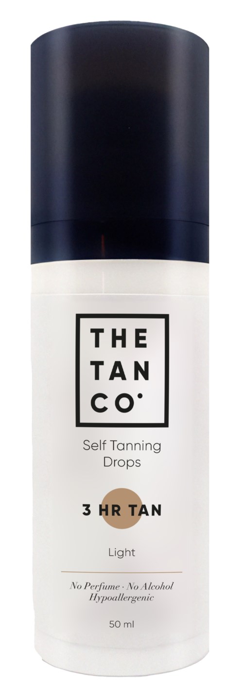 En vit flaska med svart lock, märkt "THE TAN CO." för självbruningsdroppar, ljus, utan parfym eller alkohol.