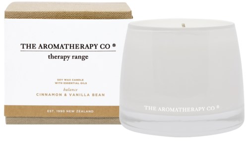 Białe świeca w szklanym słoiku z etykietą i obok pudełko, oba mają nazwę marki 'The Aromatherapy Co.' i szczegóły zapachu.