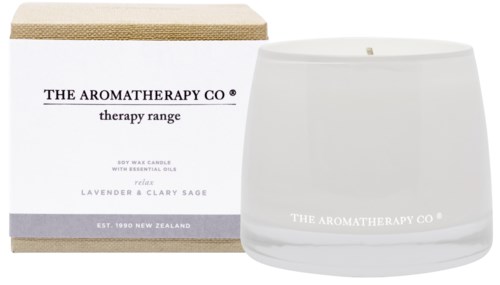 Biały świeca w szklanym naczyniu i opakowanie z napisem 'The Aromatherapy Co.' o zapachu lawendy i szałwii.