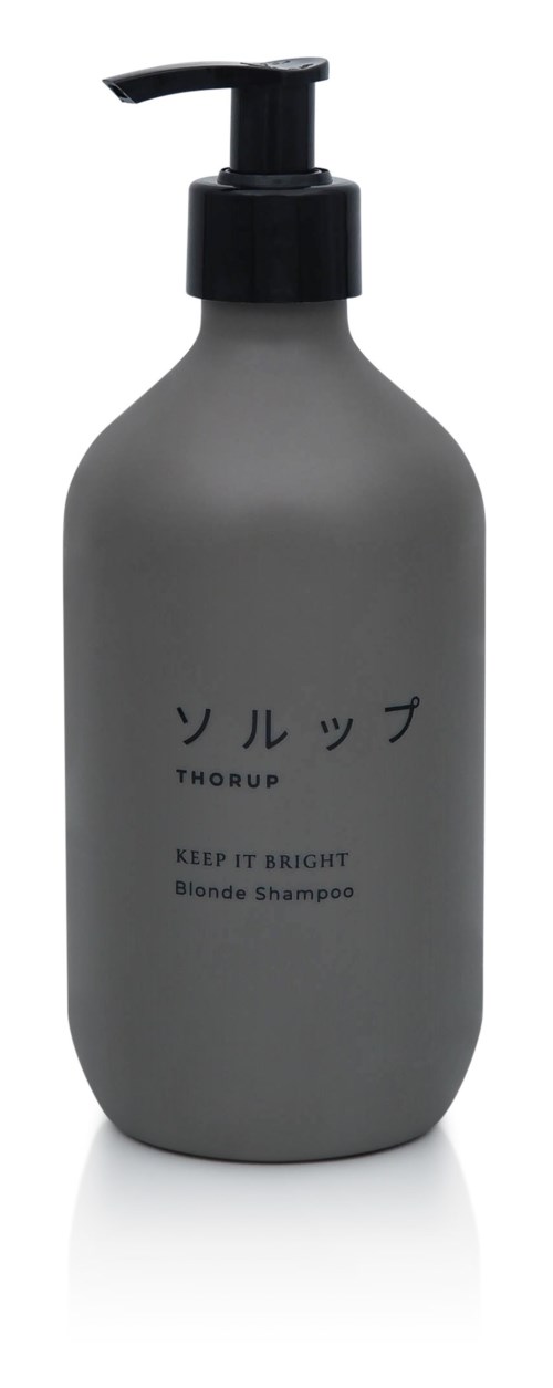 Eine graue Flasche mit schwarzem Pumpkopf, beschriftet mit japanischen Zeichen und den Worten 'Thorough' und 'Keep it bright blonde shampoo.'