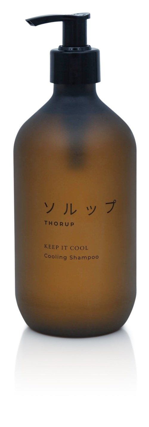 Brun flaska med svart pump märkt på japanska och engelska, säger 'Cooling Shampoo' och 'Keep It Cool'.