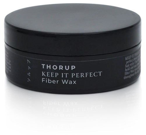 En svart rund behållare märkt "Thorup Keep It Perfect Fiber Wax" för hårstyling.