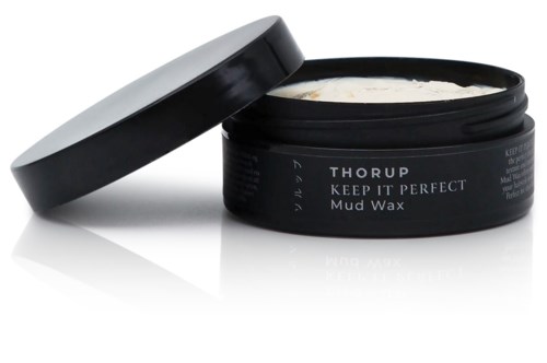 Ein schwarzer Behälter mit dem Label "Keep It Perfect Mud Wax" ist offen, zeigt weiße Wachsinnenseite.