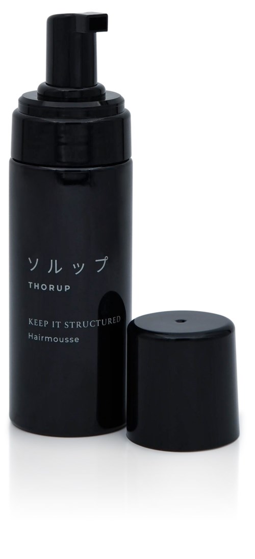 Eine schwarze Flasche mit Pumpaufsatz, beschriftet mit japanischen Zeichen und englischem Text, wahrscheinlich ein Haarschaumprodukt.