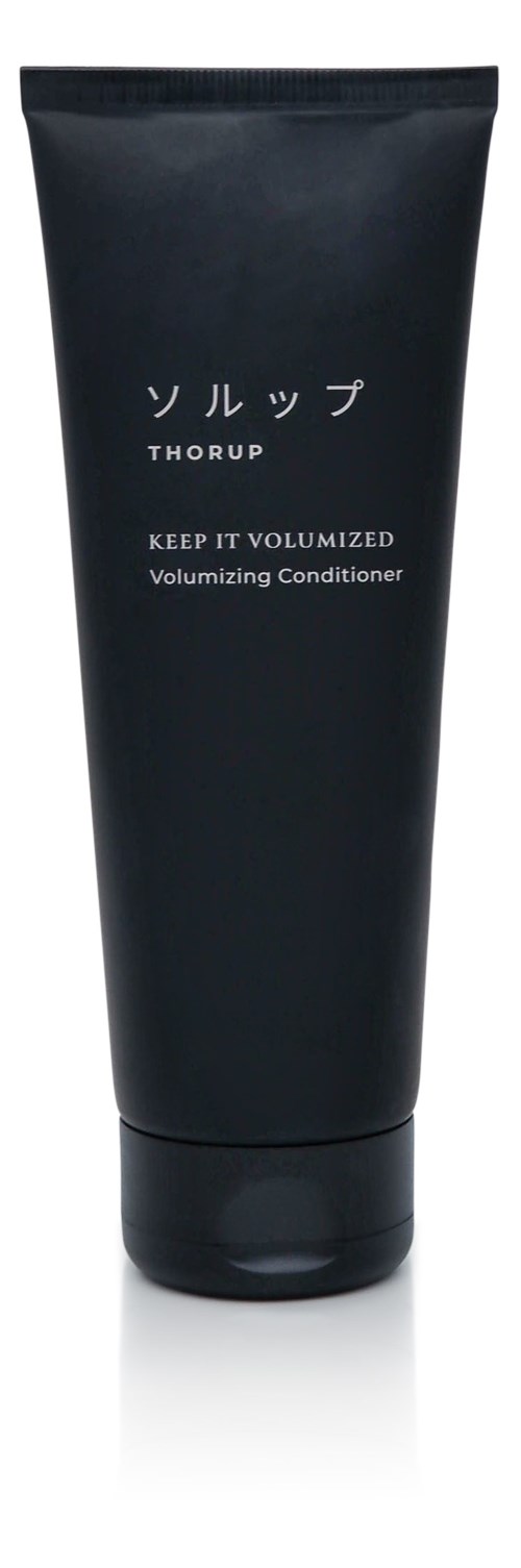 En svart tube med japansk tekst, orden 'Keep It Volumized' og en hvit etikett.
