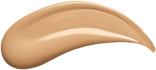 Beige-värinen kerma tai meikkivoide kaarevassa muodossa. Se vaikuttaa paksulta ja sileältä, mustan taustan päällä.