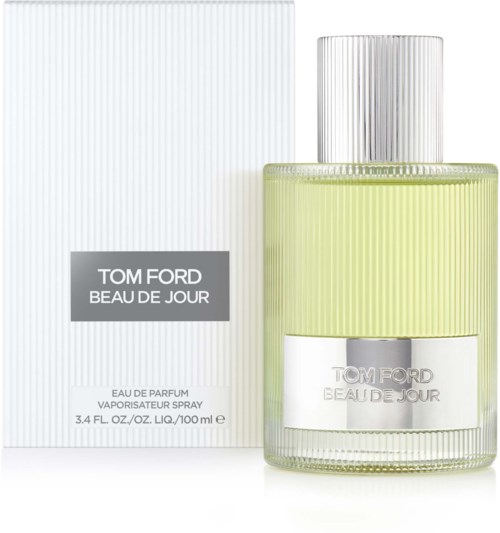 Een Tom Ford parfumfles met zilverkleurige dop, gele vloeistof en een witte doos met grijze en zwarte tekst.