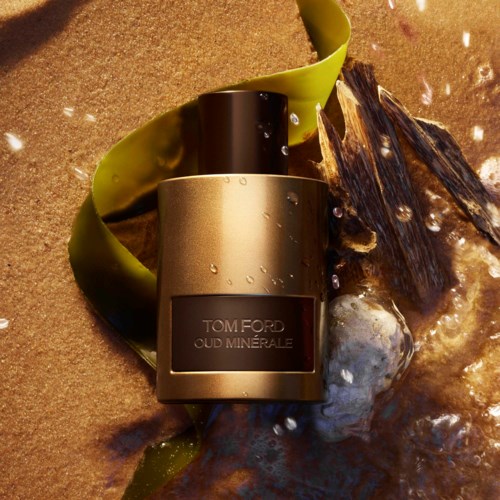 Tom Ford Oud Minérale -tuoksupullon ympärillä on kiviä, merilevää ja kuplia, luoden ylellisen ja luonnollisen näkymän.