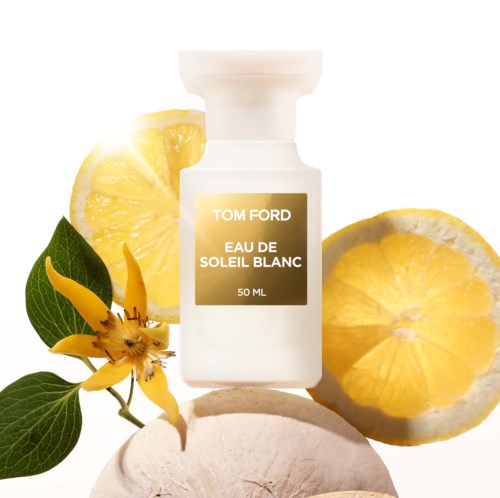 En parfymflaska märkt 'Tom Ford Eau de Soleil Blanc' omgiven av citronskivor och gula blommor.