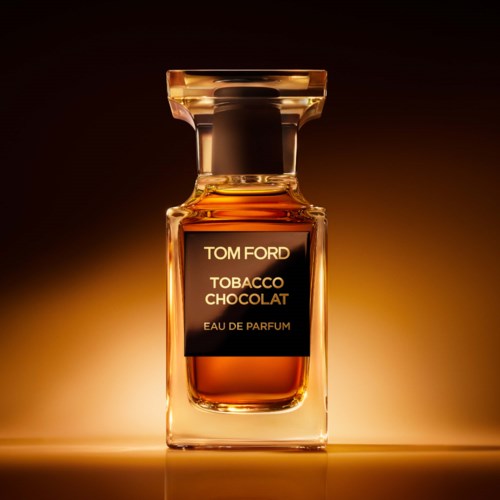 Parfymflaska med svart etikett som säger Tom Ford Tobacco Chocolat, mot en varm, gradient bakgrund.