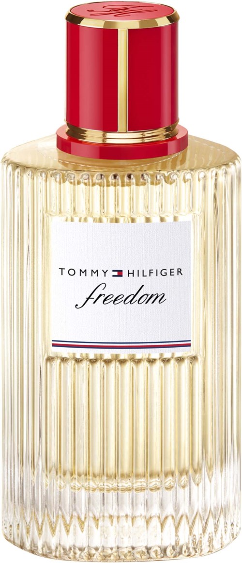 Eine hohe Parfümflasche mit gerippter Glasstruktur, einem weißen Etikett und einem gold-rotfarbenen Deckel. Das Etikett sagt Tommy Hilfiger freedom.