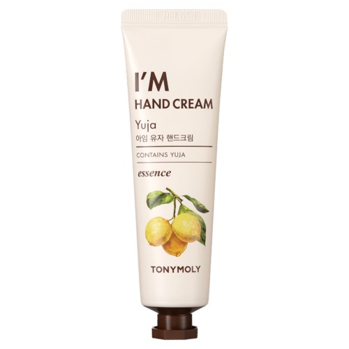 En vit handen handkrämstub med gula frukter och gröna blad, märkt 'I'M HAND CREAM' och 'TONYMOLY.'