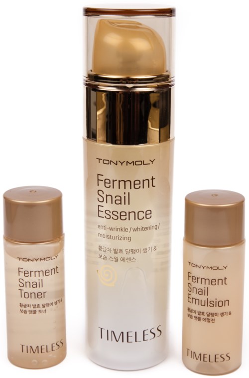 En hudvårdsset med tre flaskor: toner, essens och emulsion, i beige och guld förpackning.