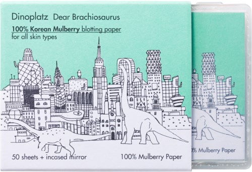 Förpackning med bläckpapper med stadssilhuett och dinosaurieillustrationer, märkt som koreanskt mullbärspapper för alla hudtyper.