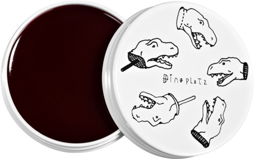 En vit behållare med skisser av dinosaurierhuvuden och texten 'Dinoplatz.' Lockets visar flera dinosauriehuvuden, några med öppen mun.