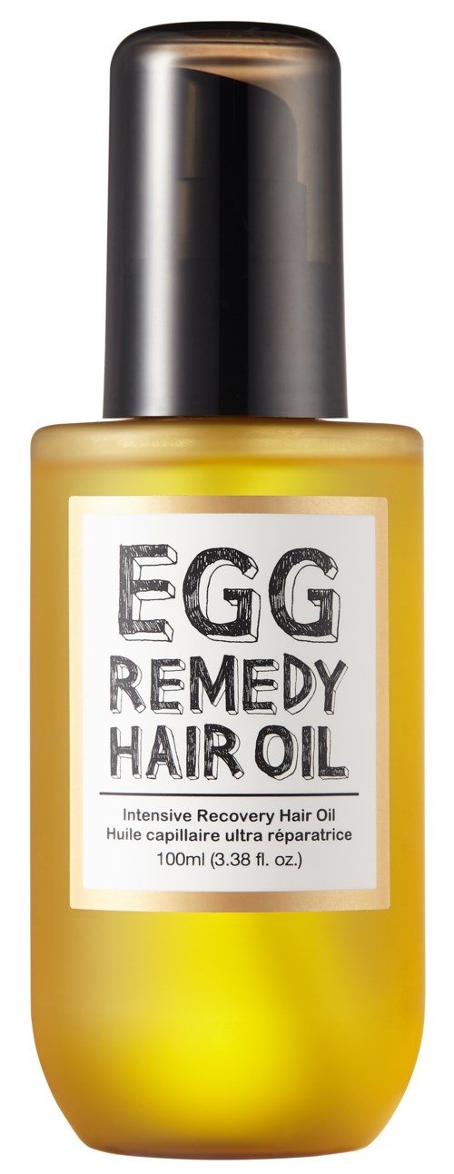 En gul flaska med svart lock märkt "Egg Remedy Hair Oil" för hårvård.