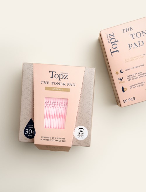 Förpackning med 50 rosa tonerpad för hudvård, inspirerad av japansk teknik, lämplig för veckovis användning.
