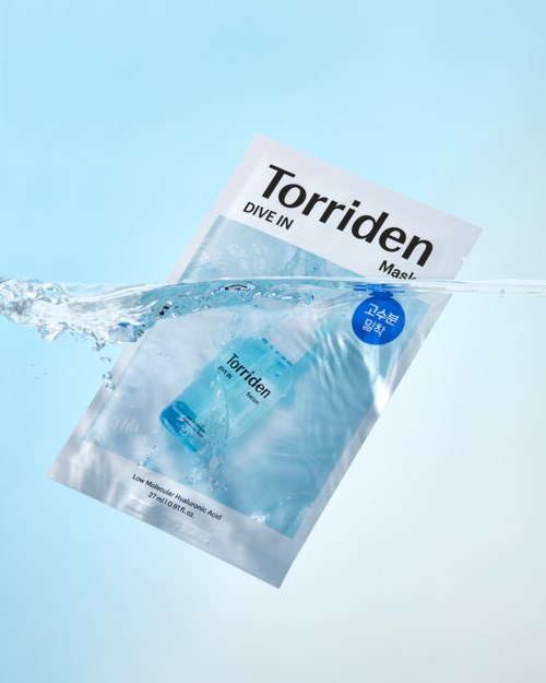En pose mærket Torriden Dive In Mask nedsænket i vand, med vandstænk omkring.