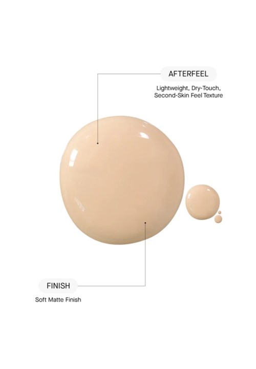 Ett beige, runt hudvårdsprodukt droppe med etiketter för efterkänsla och finish, som visar en slät textur och matt yta.