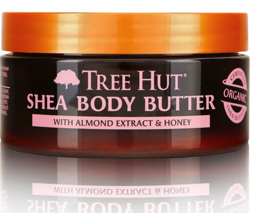 Orange lock på en mörk burk med Tree Hut Shea Body Butter med mandelextrakt och honung.