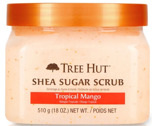 En krukke med Tree Hut Shea Sugar Scrub med tropisk mango duft, oransje lokk, og produktinformasjon på etiketten.