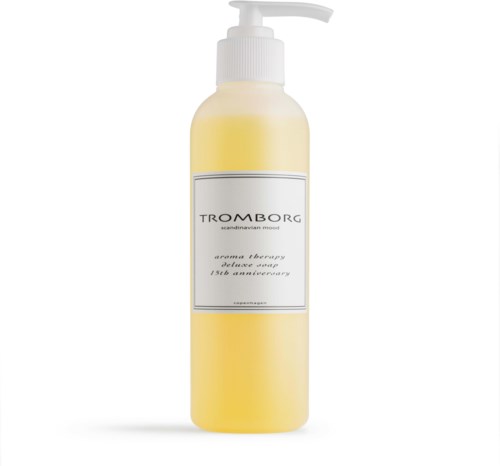En gul flaske med pumpe, mærket 'TROMBORG Scandinavian Mood'. Det er et produkt til aromaterapi eller kropspleje.