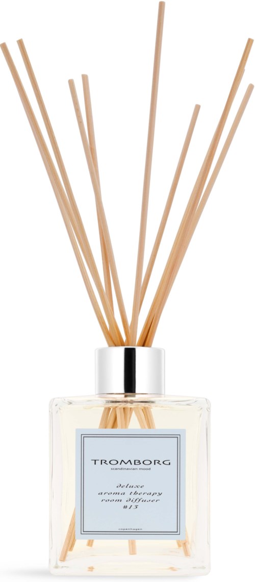 A glass bottle with a label and wooden sticks sticking out, likely a fragrance diffuser.